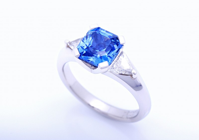 Radiant cut blue Ceylonese sapphire with trillion cut diamonds set in platinum. Custom design and hand made item of fine jewellery